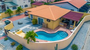 A residential property with a swimming pool, a covered patio, and a car parked outside. - Casa de Reyes (Noord)