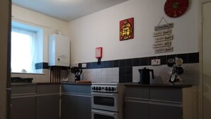 Eine Küche mit Herd, Backofen und einer Uhr an der Wand.