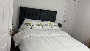 A neatly made bed with white bedding and pillows featuring the 'Whitford Living' logo. - Ground Floor Property - Sleeps 2 - Parking - Garden (Jarrow)