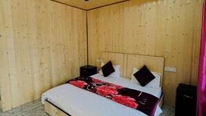 Puupaneloitu huone, jossa on sänky, yöpöydät ja marmorilattia.