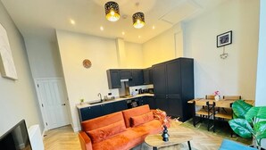 Ein modernes Wohnzimmer mit einer Couch, einem Couchtisch und einem Essbereich mit Tisch und Stühlen.