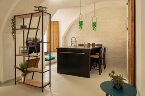 Eine moderne Küche mit einer zentralen Kochinsel, Pendelleuchten und einem geometrischen Regalsystem.