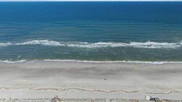 Ein Strand mit freiem Blick auf den Ozean und einem sandigen Ufer.