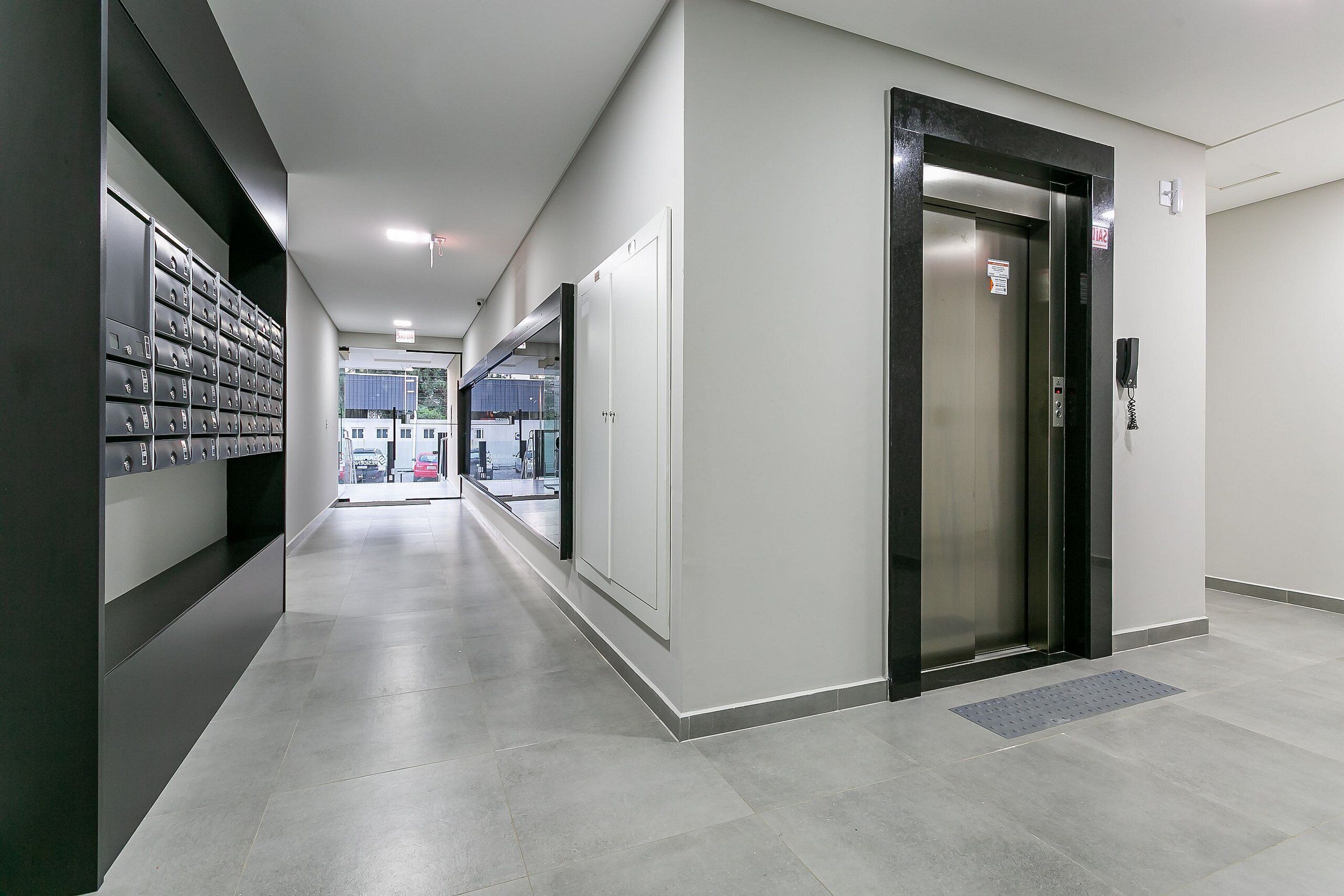 Een moderne hal met kasten, een lift en vrij uitzicht.