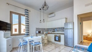 Una cucina compatta con zona pranzo, TV e tappeto decorato.