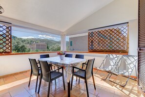 Un comedor con mesa, sillas y vistas a las montañas.