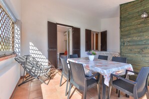 Un comedor con una mesa, sillas y una planta en maceta.