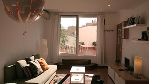 Uma sala de estar moderna com sofá, mesa de centro e vista para o exterior.