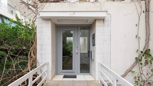Une entrée moderne avec une porte en verre et un petit espace de porche.