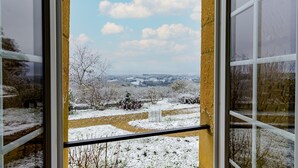 Una vista attraverso una finestra, con cielo sereno e paesaggio innevato.
