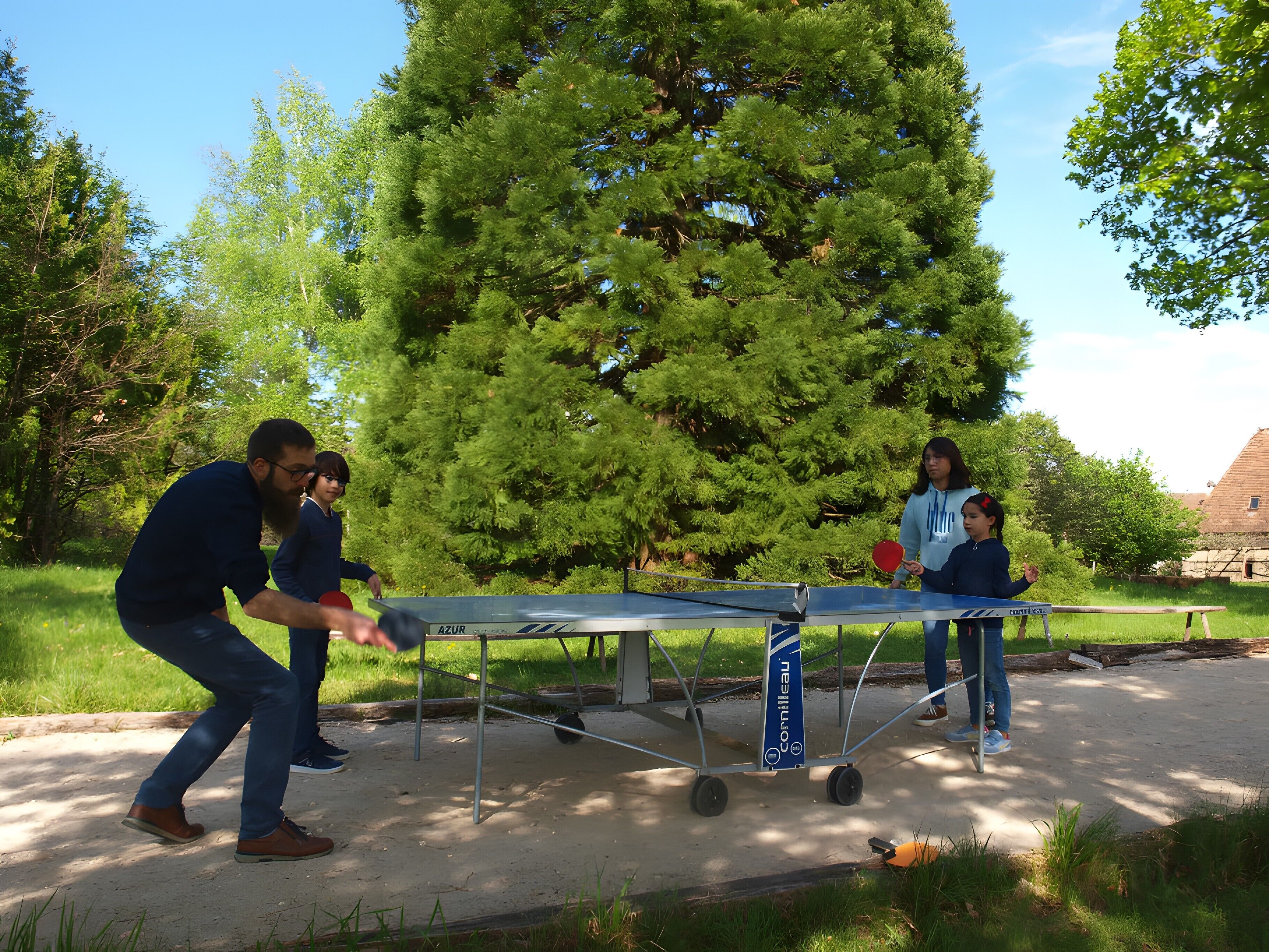 Une table de ping-pong installée en plein air, avec des arbres et un bâtiment en arrière-plan.