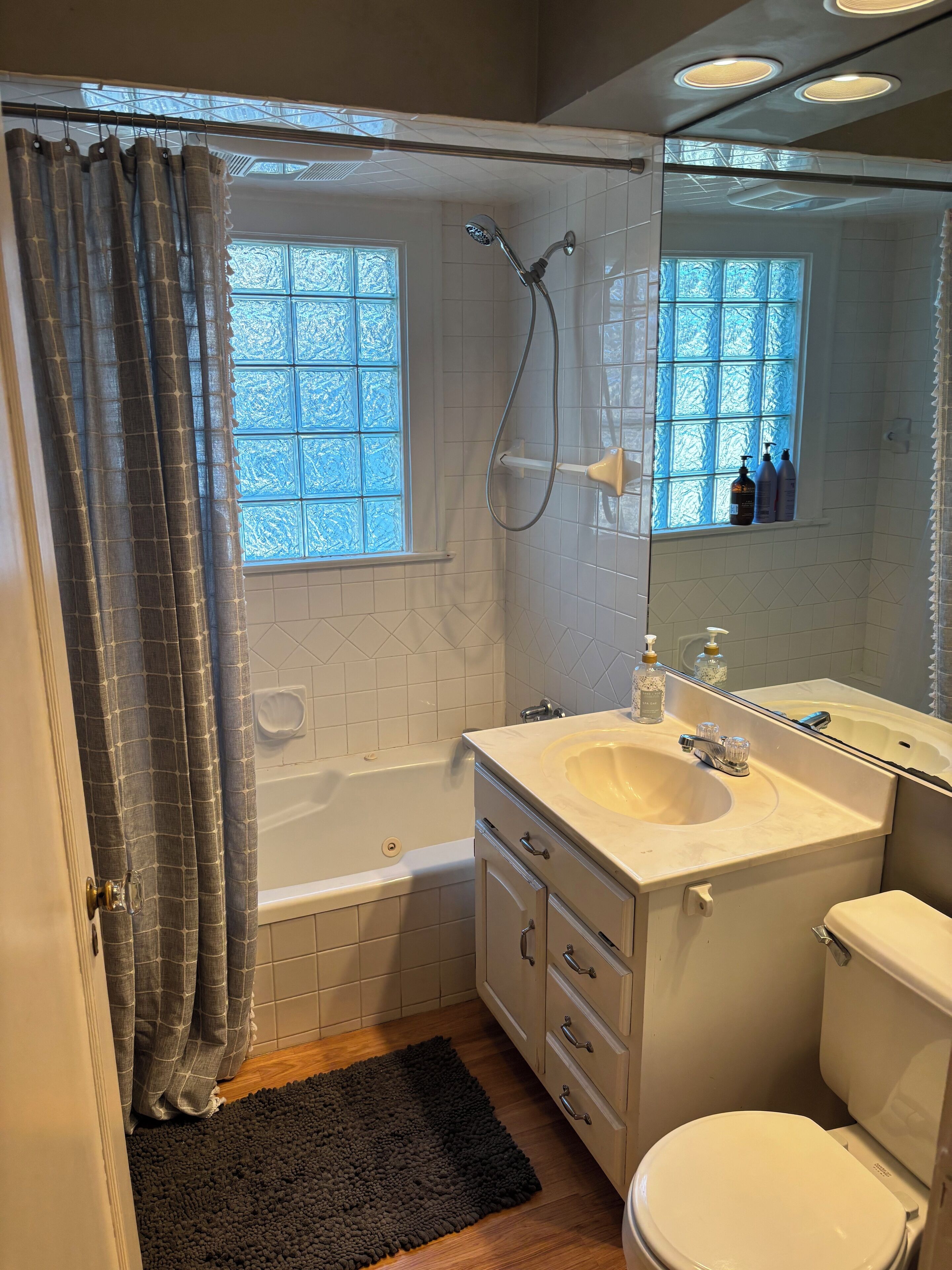 Een badkamer met een bad, wastafel, toilet en douche.