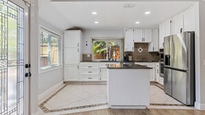 A spacious kitchen with white cabinetry, a large island, and stainless steel appliances. - 3BR · Pool · Hot Tub · BBQ · Garage · Roseville (Roseville)