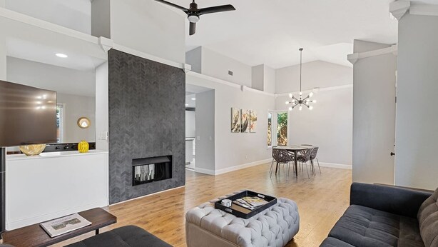 A spacious living room with a fireplace, a dining area with a round table and chairs, and a modern ceiling fan. - 3BR · Pool · Hot Tub · BBQ · Garage · Roseville (Roseville)