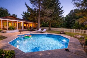 A rectangular swimming pool with a tiled edge, surrounded by a concrete deck. There are lounge chairs and a small inflatable pool float. - Private Pool & Hot Tub Near Kalahari (Cresco)