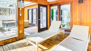 A wooden interior with a glass door leading to a patio area.