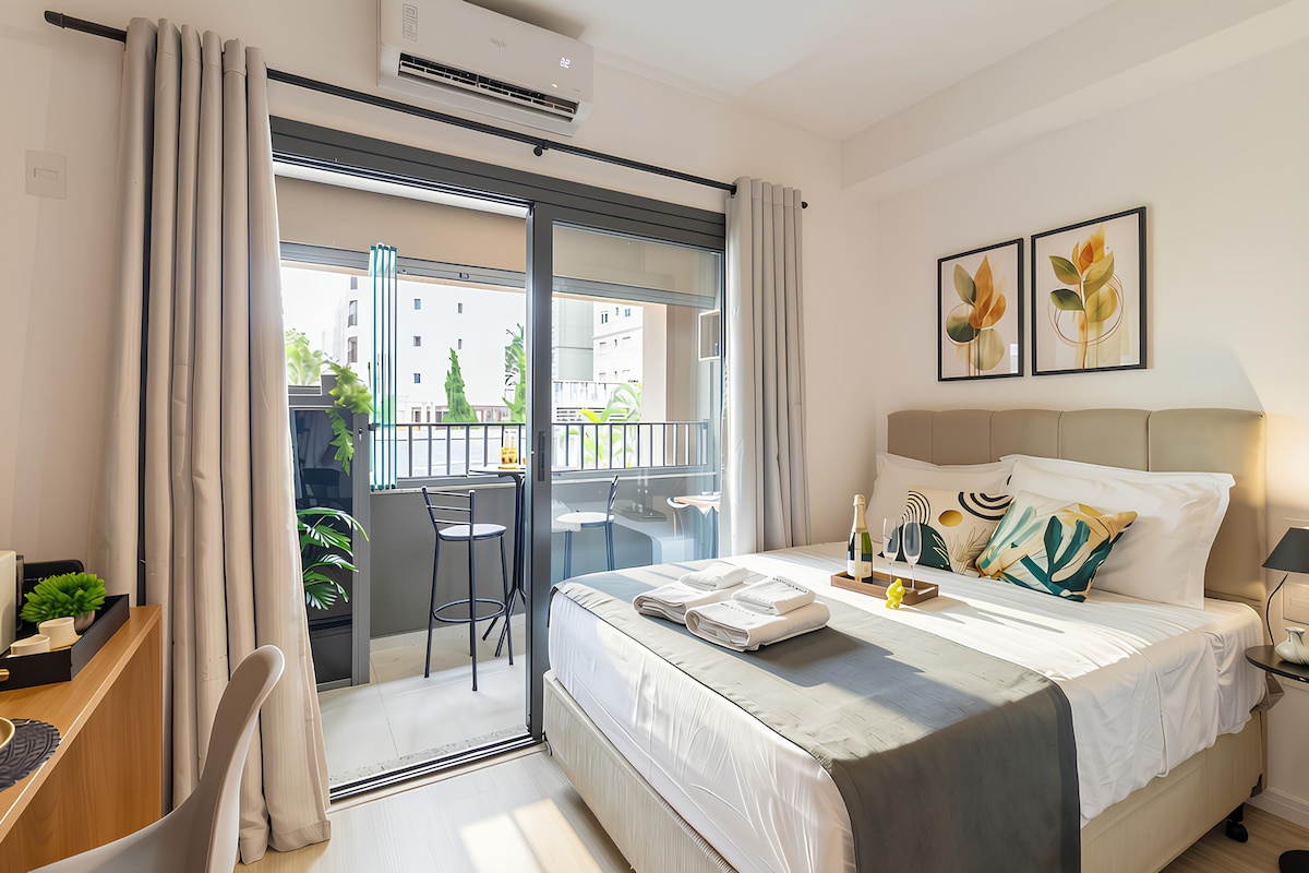 Ein modernes Hotelzimmer mit einem Bett, einem Schreibtisch, einem Stuhl, einem Balkon und Bildern an der Wand.