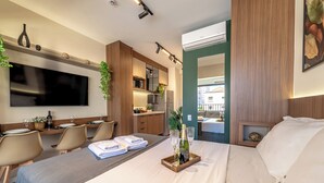 A hotel room with a bed, a TV, a dining area, and a kitchenette. - Vila Mariana near Ibirapuera Park (São Paulo)