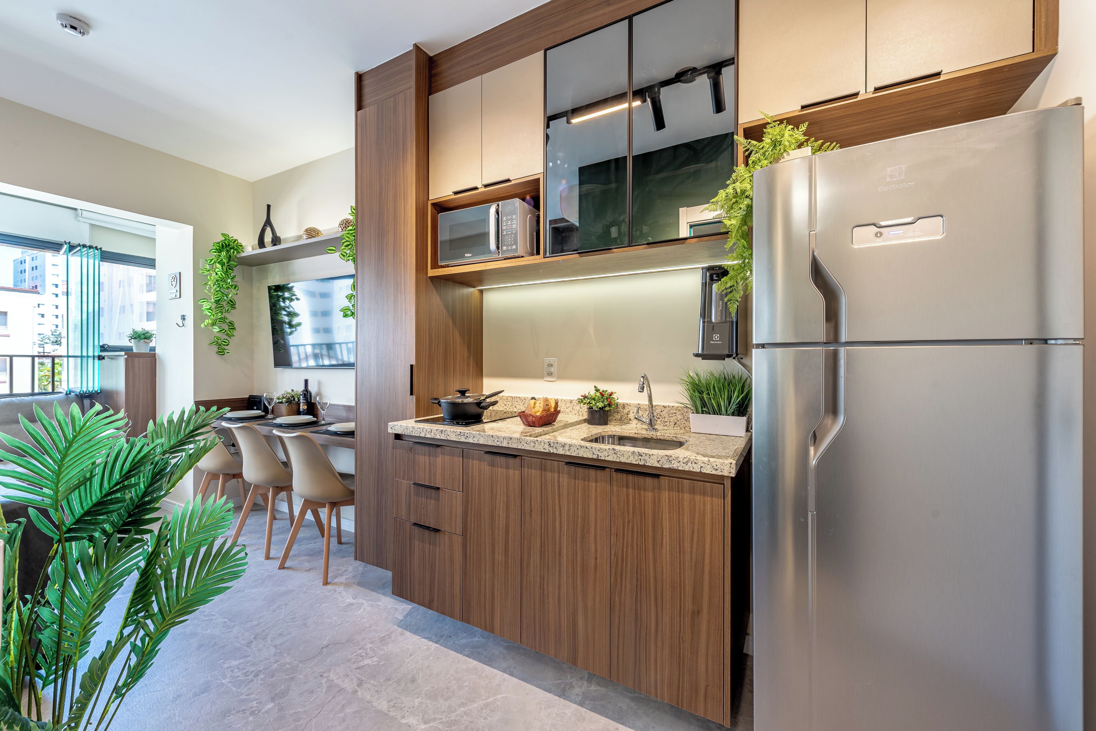 Una cocina moderna con armarios de madera, un refrigerador de acero inoxidable y un microondas integrado.
