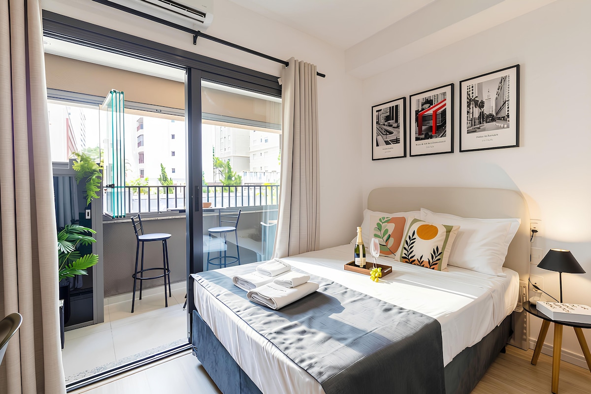 Ein modernes Hotelzimmer mit Balkon, einem Bett mit Blick und einem kleinen Tisch mit Flasche und Gläsern.