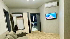 A modern living room with a sofa, a flat-screen TV mounted on the wall, and a wooden floor. - River View (Raionul Soroca)