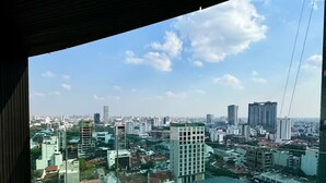 A high-rise building with a view of a cityscape, including various buildings and a clear sky.