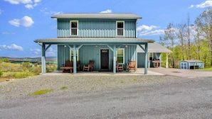 A two-story house with a porch, a garage, and a small shed. - Raven Feather Retreat : Pet Friendly! (Liberty Township)