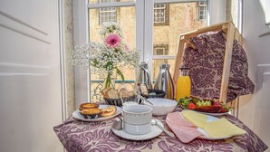Een ontbijttafel met diverse soorten eten, zoals gebak, fruit en een kop koffie.