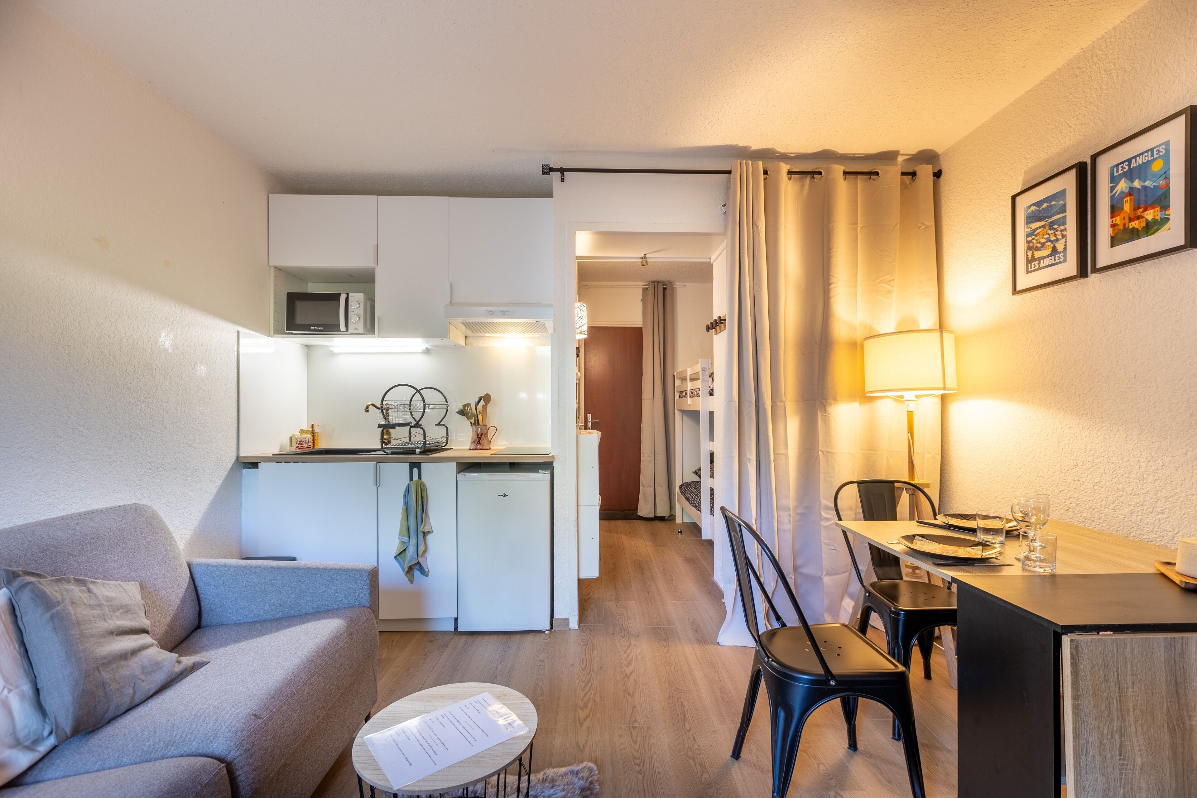 A compact living space with a kitchenette, a dining area, and a seating area.