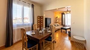 Un comedor con una mesa de madera preparada para cuatro personas, un radiador y vistas al exterior.