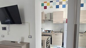 Une cuisine moderne avec des armoires blanches et un sol à carreaux aux couleurs vives.