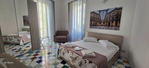 Ein Hotelzimmer mit einem großen Bett, einem Sessel, einem kleinen Tisch und einem Spiegel.