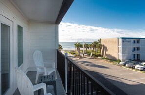 Un balcone con sedie bianche, vista sull'oceano e un edificio con la scritta "The Diplomat" sullo sfondo.