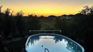 Una piscina con vistas a casas y árboles al fondo.