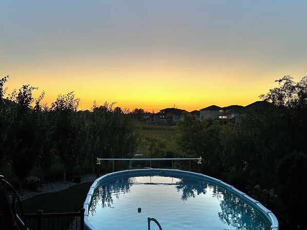 A swimming pool with a view of houses and trees in the background.
