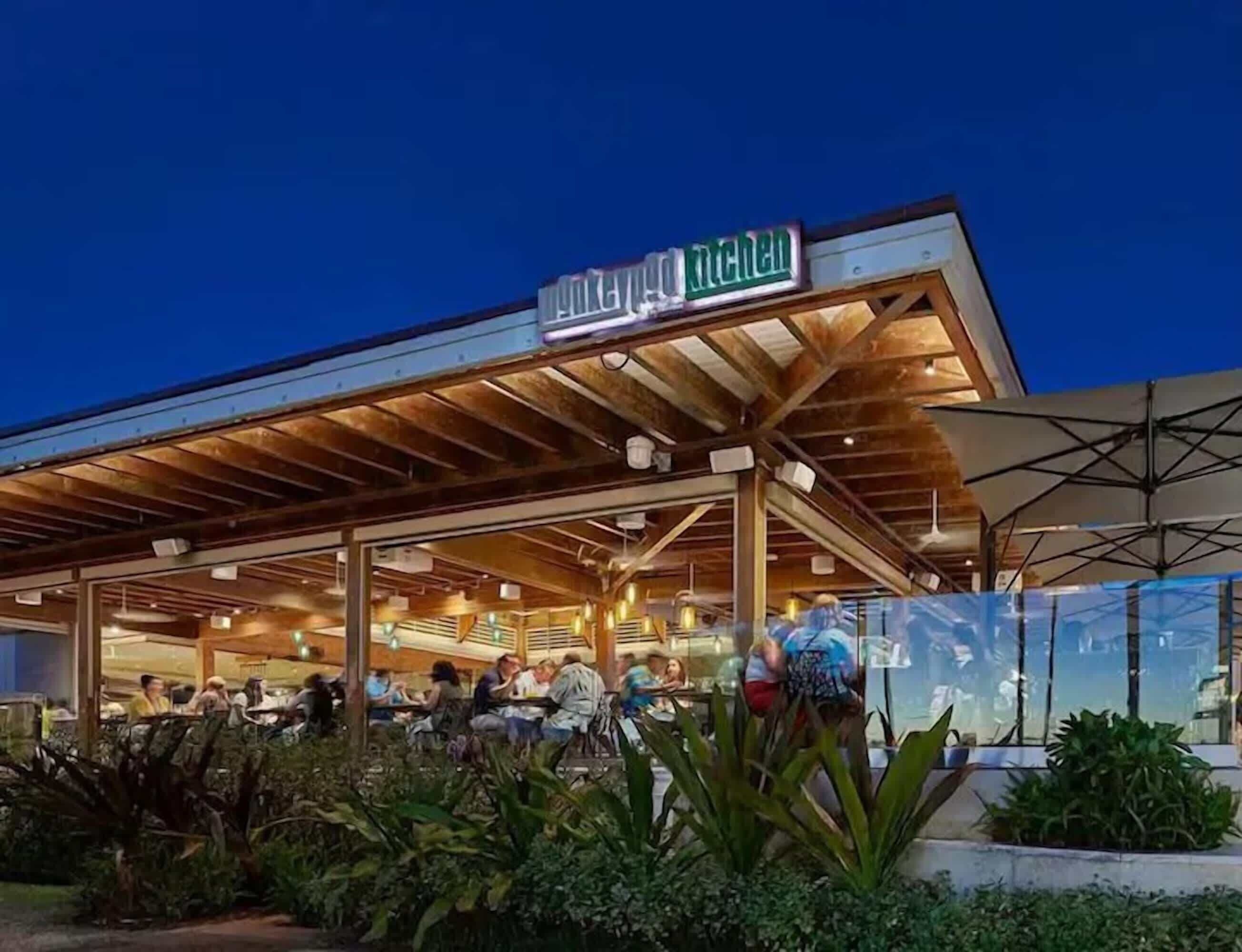 An outdoor dining area with a covered roof and a sign reading "KITCHEN".