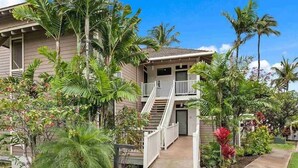 A two-story house with a balcony, surrounded by lush tropical vegetation. - Spacious Ground Floor Maui Retreat, Grand Champion (Wailea-Makena)