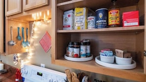 A kitchen with wooden cabinets, a stove, and various cooking ingredients and utensils. - Walkable Downtown Stay | Pet-Friendly & Spacious (Raleigh)