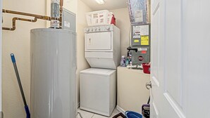 A laundry room with a water heater, washing machine, and dryer.
