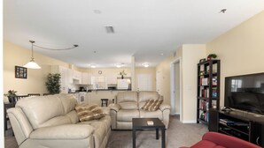 A living room with a beige sofa, a red armchair, a leather recliner, and a coffee table.
