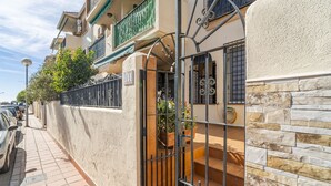 Un edificio residenziale con cancello, un balcone e un vialetto piastrellato.
