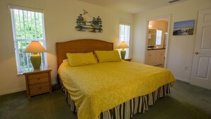 A bedroom with a bed, two bedside lamps, a nightstand, a window with blinds, a door, and a small painting on the wall. - 3 Bedroom & 2 bath with private pool (Hernando)