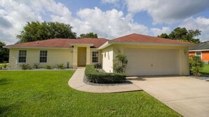 A single-story house with a red roof, a front garage, and a well-maintained lawn. - 3 Bedroom & 2 bath with private pool (Hernando)