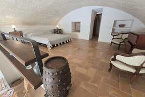 A rustic bedroom with a wooden bed, a barrel, and a bench. - VILLA FELICITA - SUNDIAL RESIDENCE (MARINA DI LEUCA)