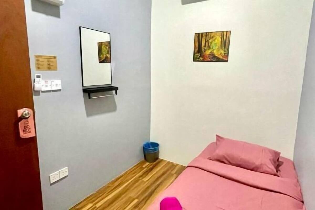 Une chambre à coucher avec un lit, un miroir et deux tableaux accrochés au mur.