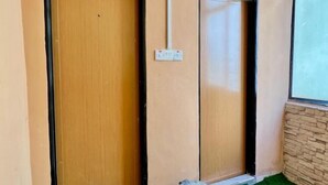 Una porta in legno con un vetro, una presa elettrica e un piccolo contenitore a terra.