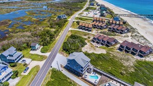 A coastal residential area with beachfront properties, a road, and a pier. - Good Tide-ings (Sneads Ferry)