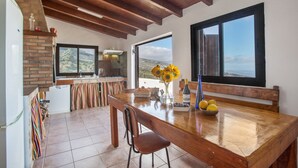 Une cuisine dotée d’un plan de travail en bois, d’un four en briques et offrant une vue par une fenêtre.