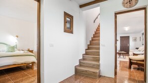 Une chambre à coucher comprenant un lit, une table de chevet, une commode et une horloge fixée au mur.