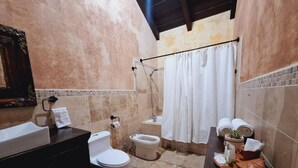 Un baño con inodoro, bidé y zona de ducha.